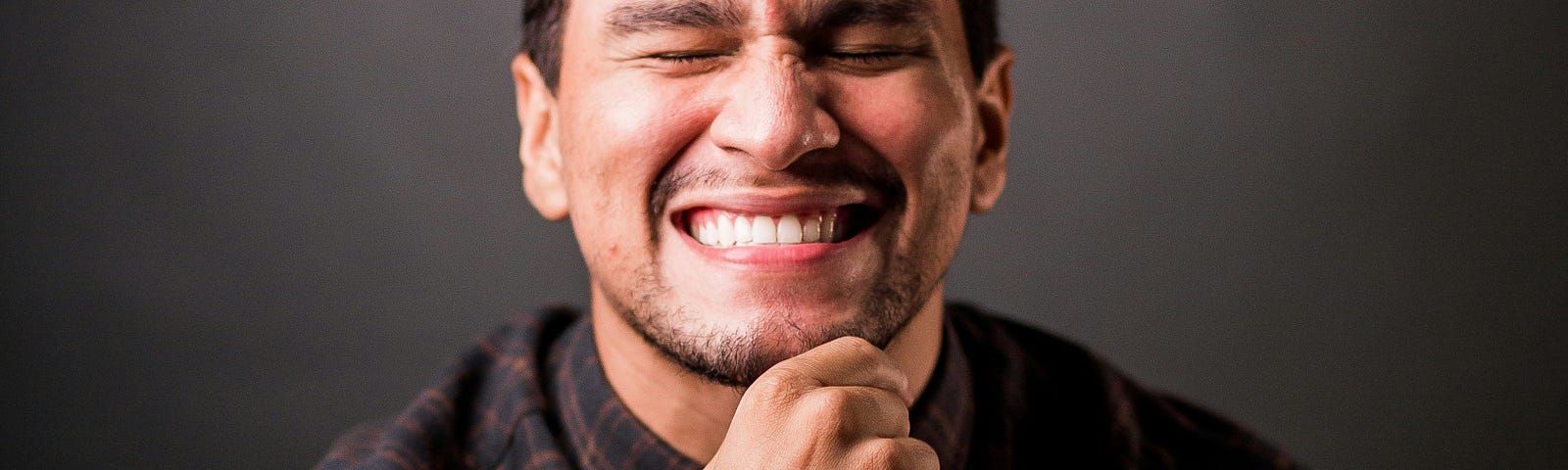 A man smiling with closed eyes