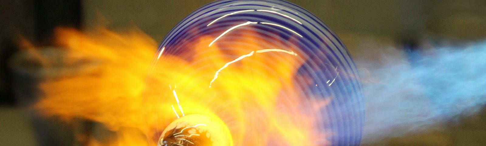 A glass piece of art being formed in a furnace.