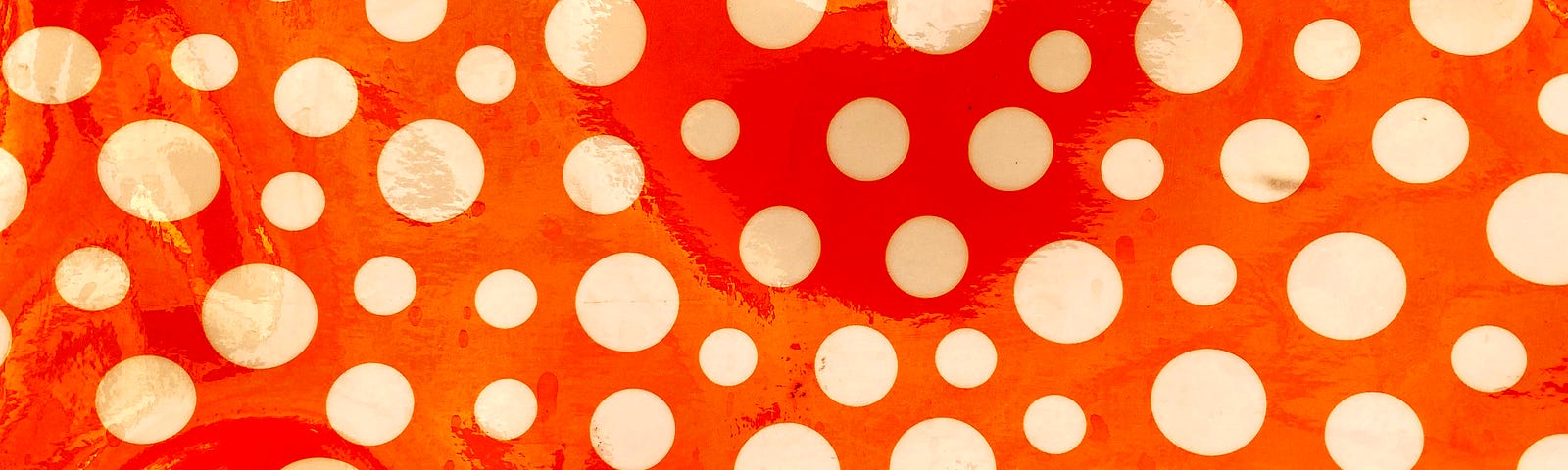 White polka dots on a red background, filling the screen.