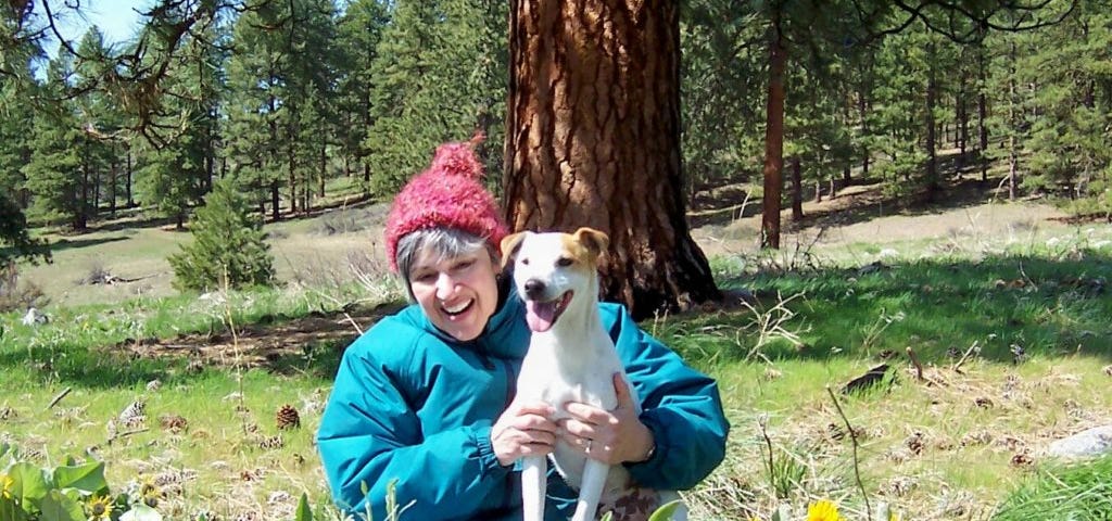 The author, Deb, holding her Jack Russell terrier, Kosmo, outside on a spring day.