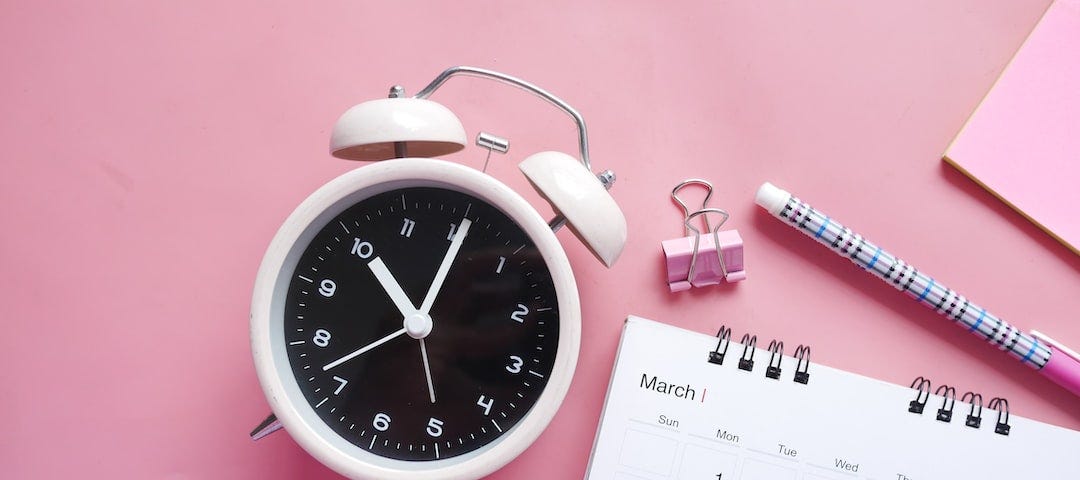 A clock, calendar, pen, and binder clip.