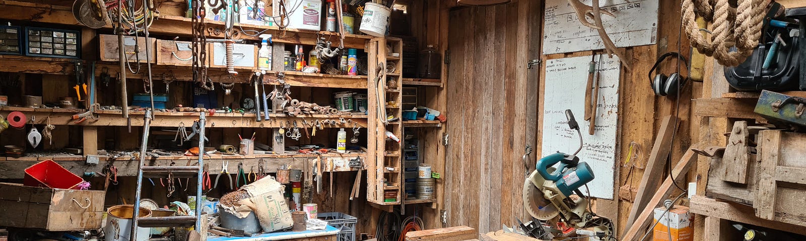 A wood shop with tools, spindles, sawdust and scraps