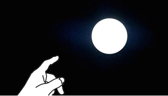 the finger pointing at the Moon