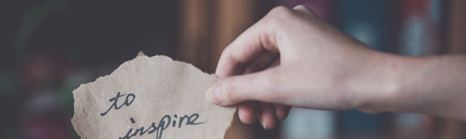 Woman holding up a note that says to inspire