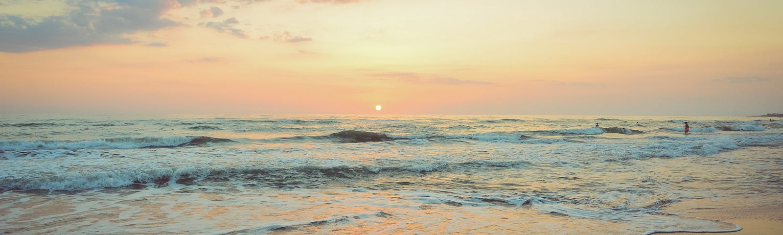 ocean surf and sand as the sun begins to set