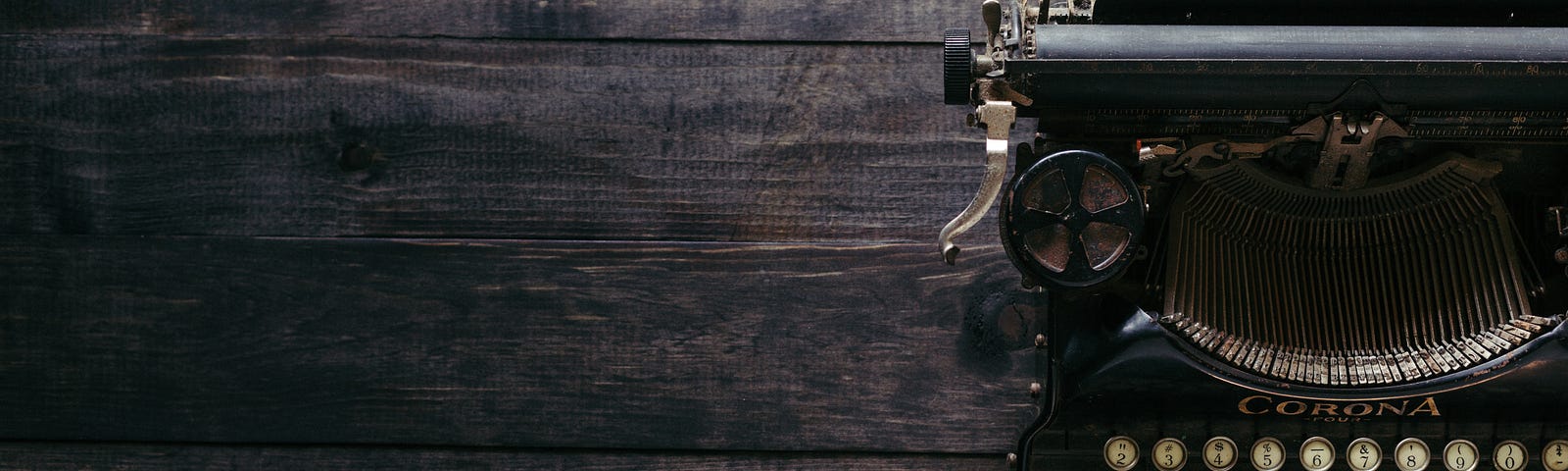 An antique typewriter sits on a wooden desk