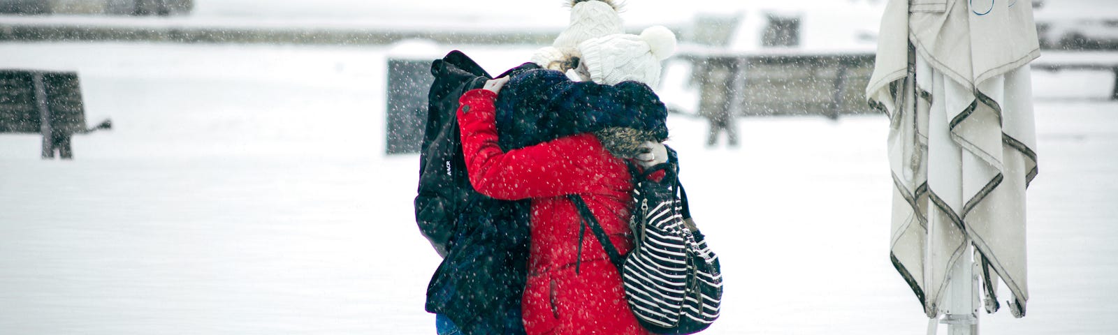 Two people hugging in the snow.