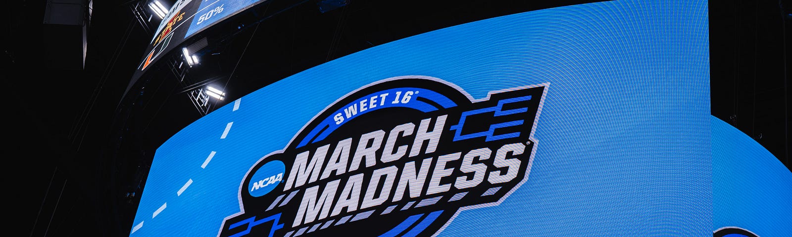 a jumbotron with March Madness on the screen