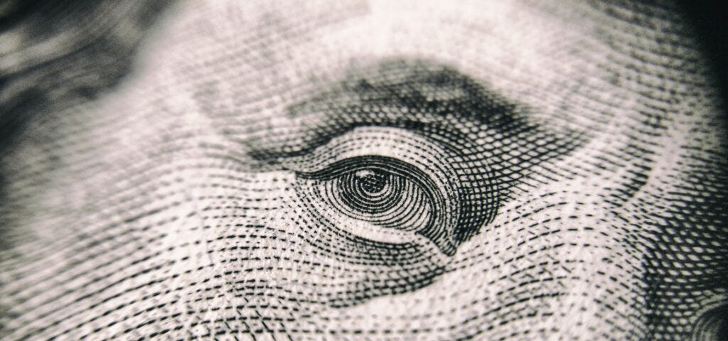 Focused view of Ben Franklin’s right eye from the US $100 bill. Photo courtesy of Vladislav Reshetnyak at Pexels.
