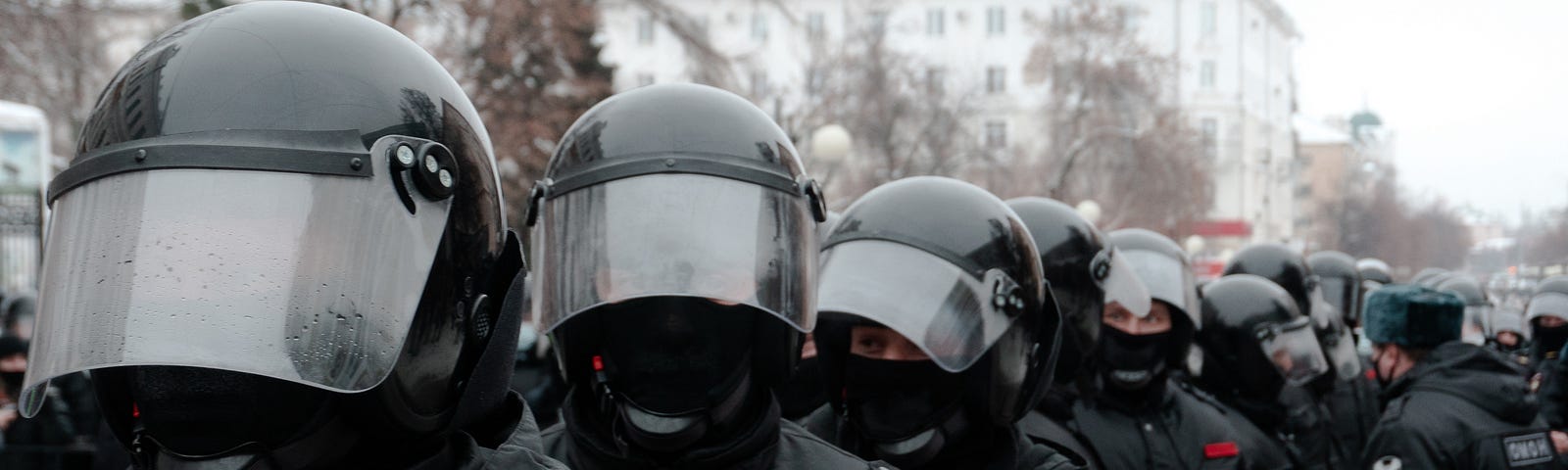 Police forces dressed in black with helmets.