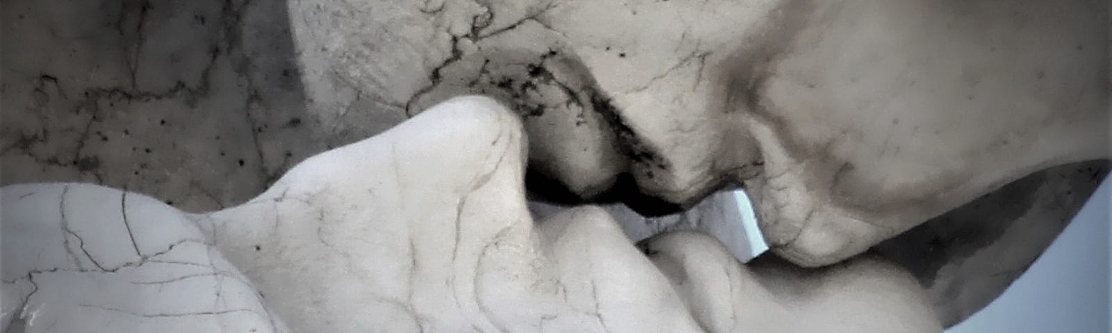 two stone faces kissing each other