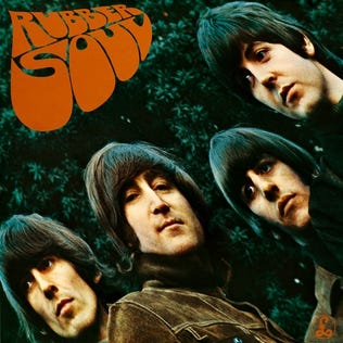The Beatles “Rubber Soul” album cover art that “The Word” appears on; Beatles members in brown coats shown diagonally bottom left to top right (George Harrison, John Lennon, Ringo Starr, Paul McCartney) on green tree background and album name in orange 60s-esque font in top left