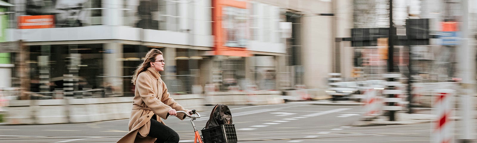A woman riding a bike through an intersection.