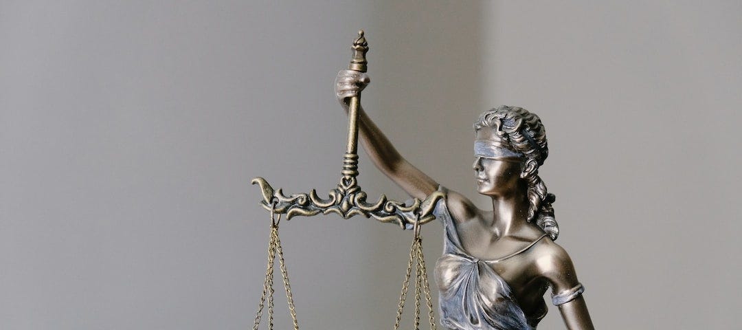 A bronze statue of Lady Justice holding a scale.