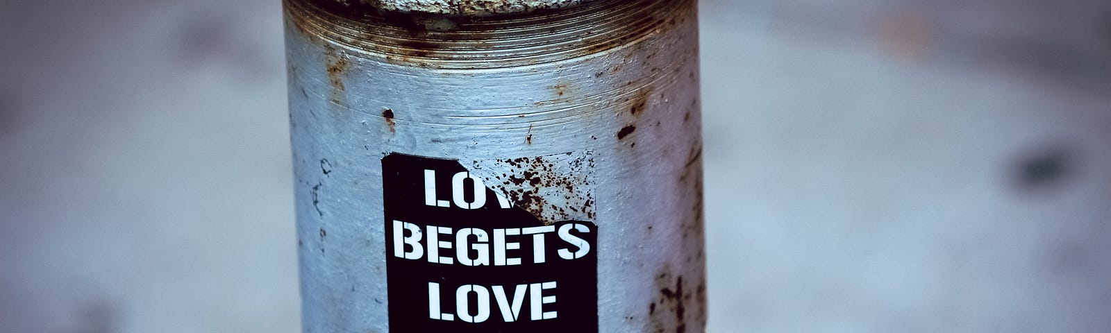 a bumper sticker on a post “Love Begets Love Hate Begets Hate”