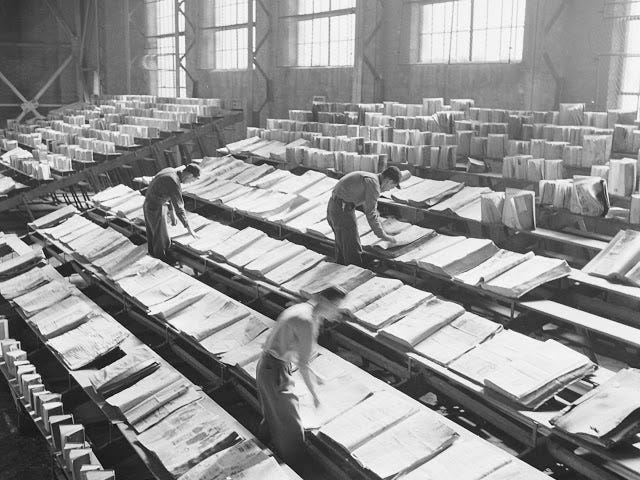 Men drying out state library books damaged by fighting the Lewis Cass State Office Building fire in Michigan, 1951.