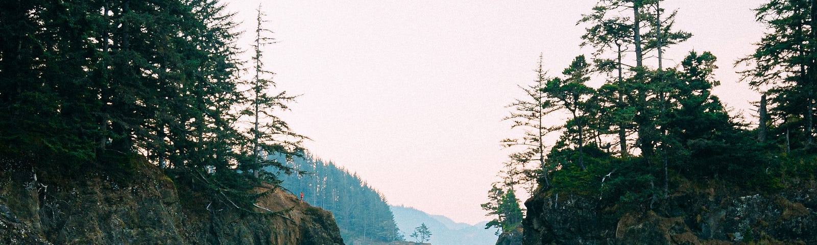 A lady watching a body of water amidst boulders