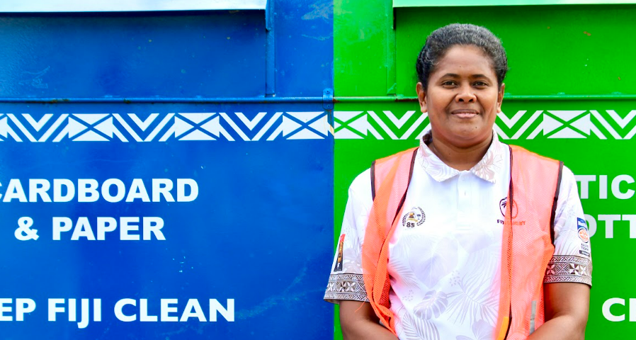 A woman stands in front of a recycling hub.