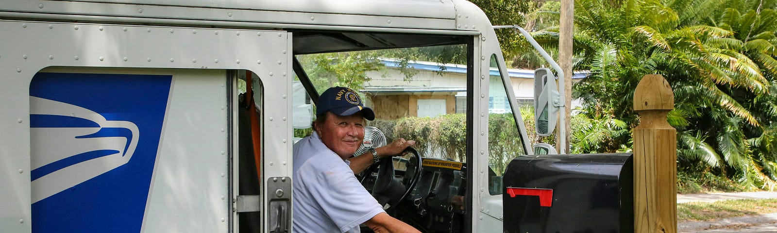 A postman in his car delivering mail.