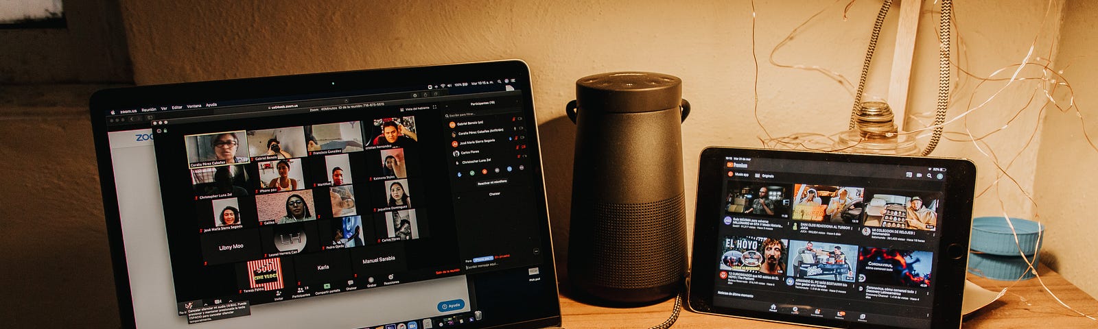 A desk with a computer and a tablet with a Zoom Vidoe Conference on both screens