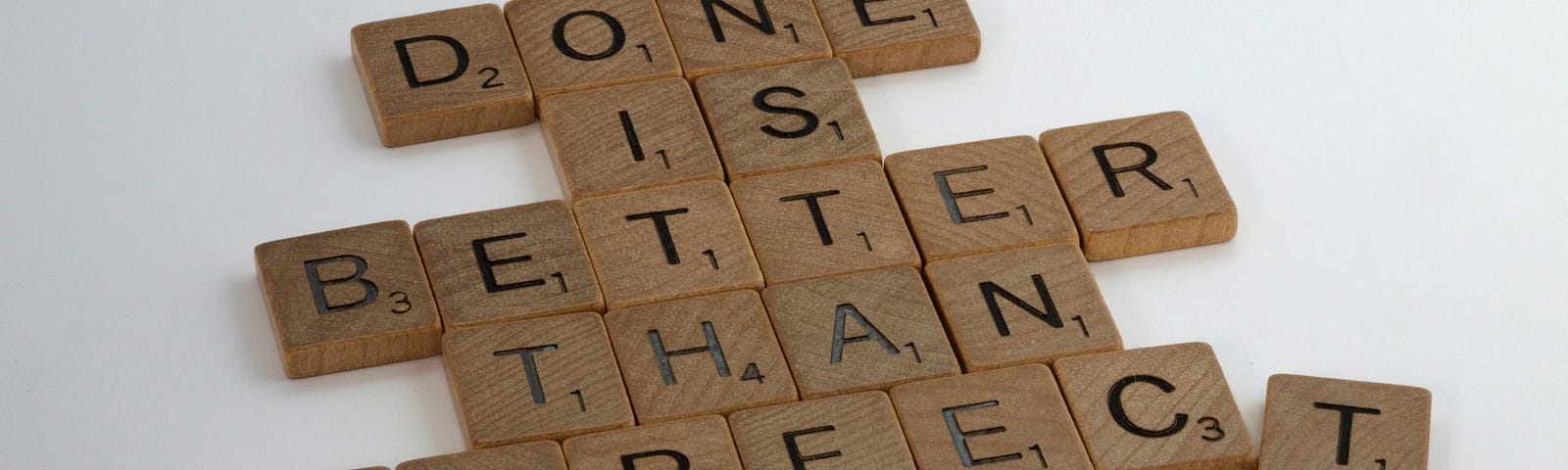 Scrabble pieces spelling out “Done is Better Than Perfect.”