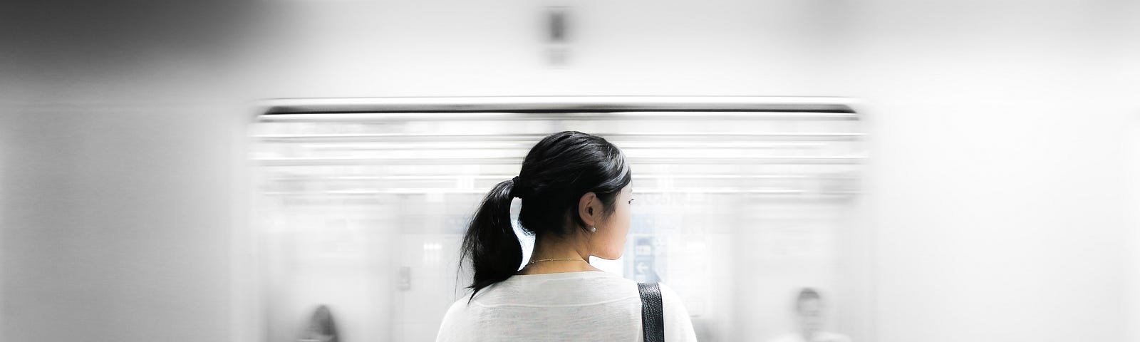 A woman standing on the platform waiting for the train