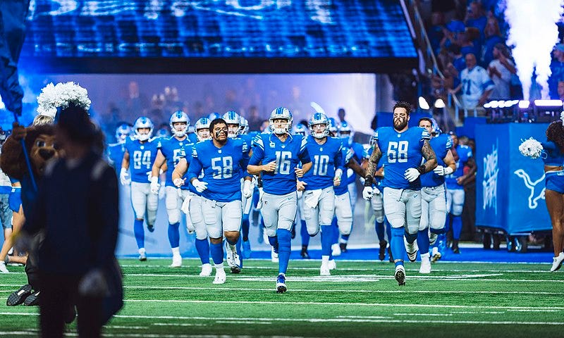 The Detroit Lions running onto the field.