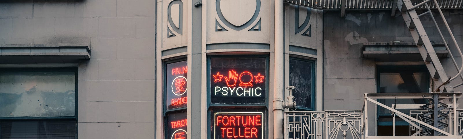 Picture of a window with a neon sign advertising for a psychic reader.