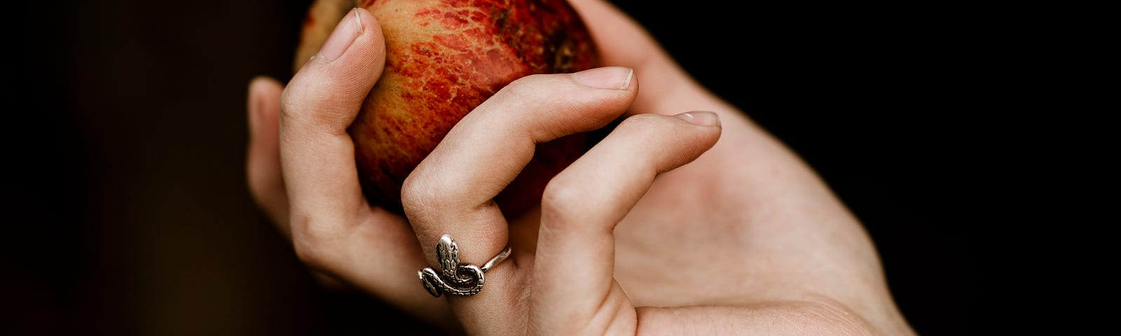 A woman’s hand offering an apple