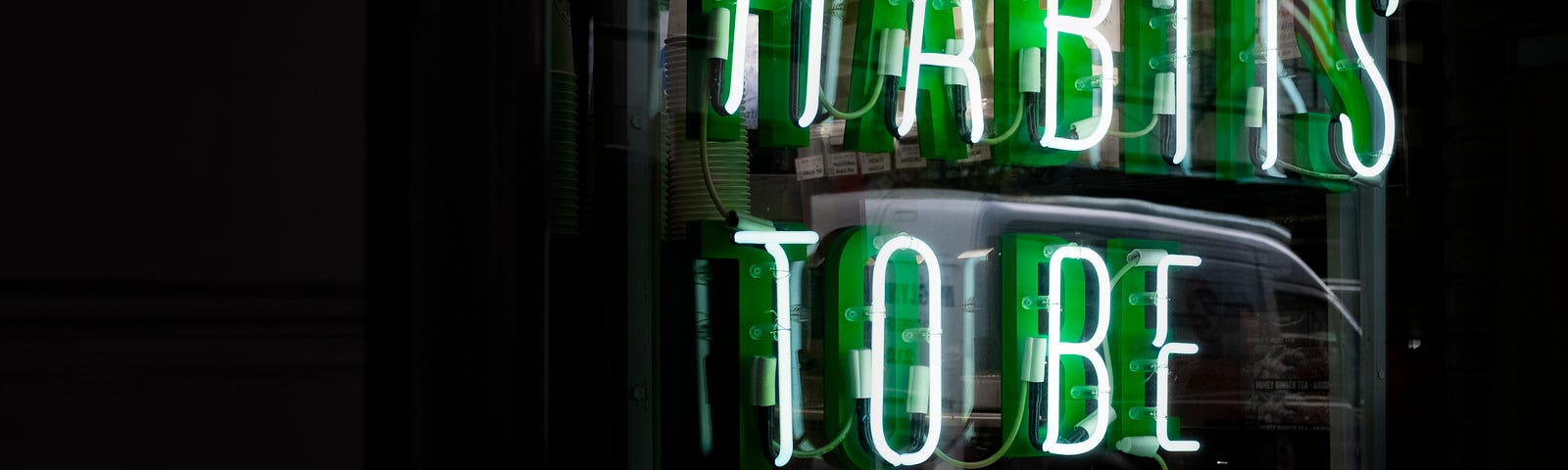 An image of a sign in green lights saying ‘Habits to be made’.