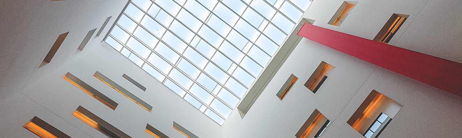 Looking up at a windowed ceiling, with windows scattered on three sides of the building.