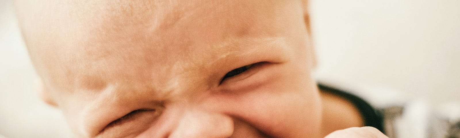 A close-up of a young baby convulsed in tears.