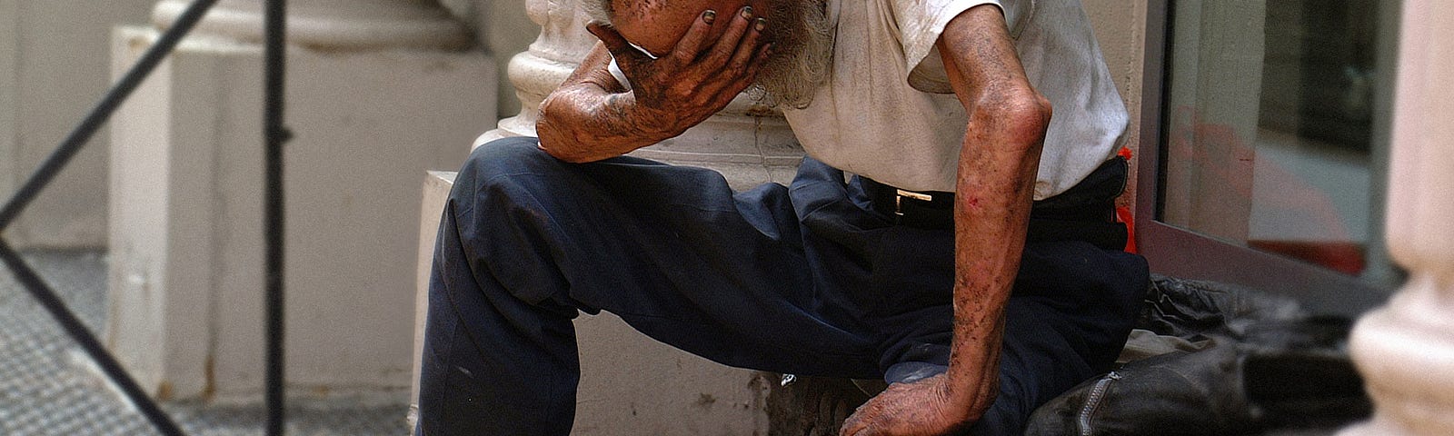 man on a stoop holding his head