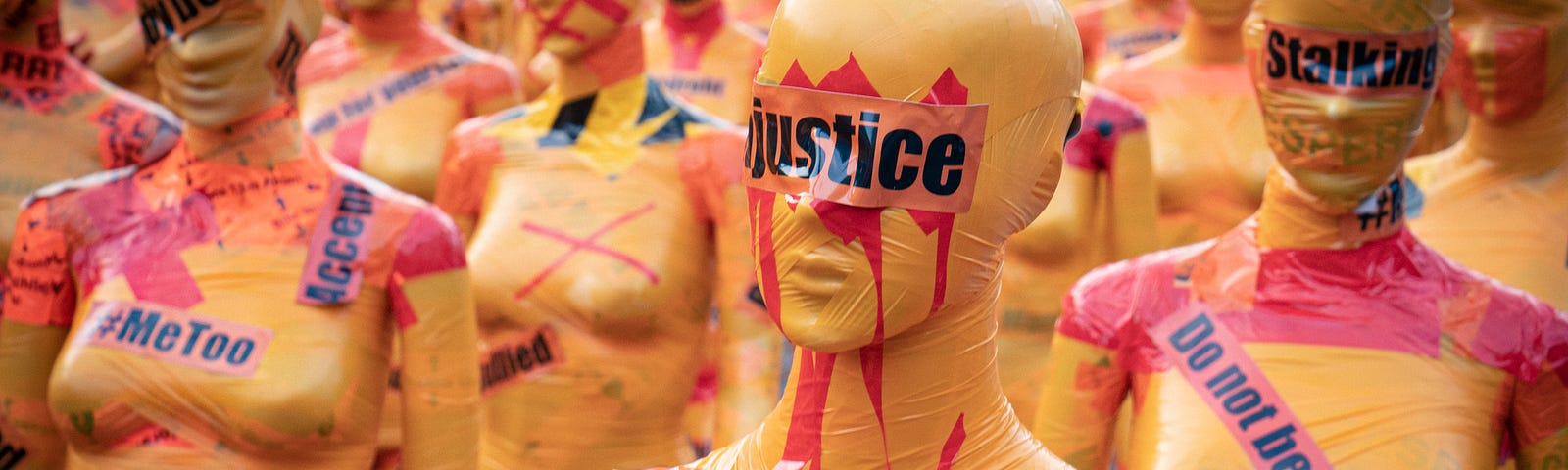 mannequins wrapped in tape with the words, ‘justice,’ ‘do not look away,’ and ‘#metoo’ as part of an art installation about violence against women.