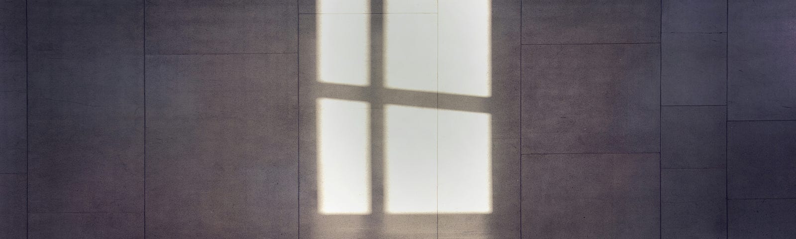 Window shadows on a huge tiled wall.