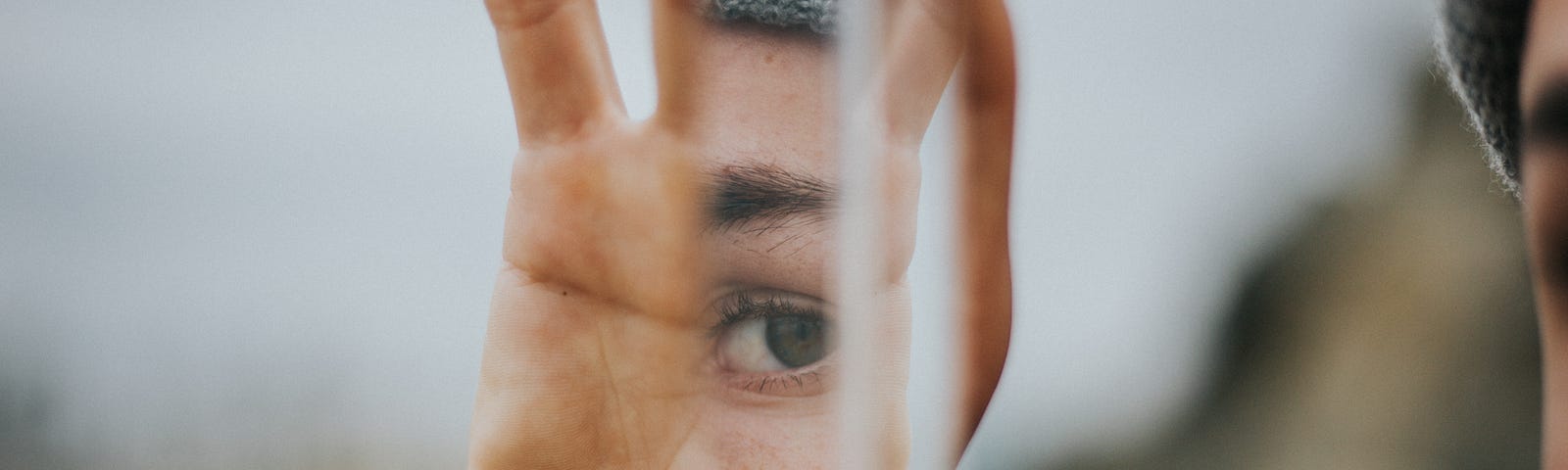 Person’s face reflected in a piece of glass.