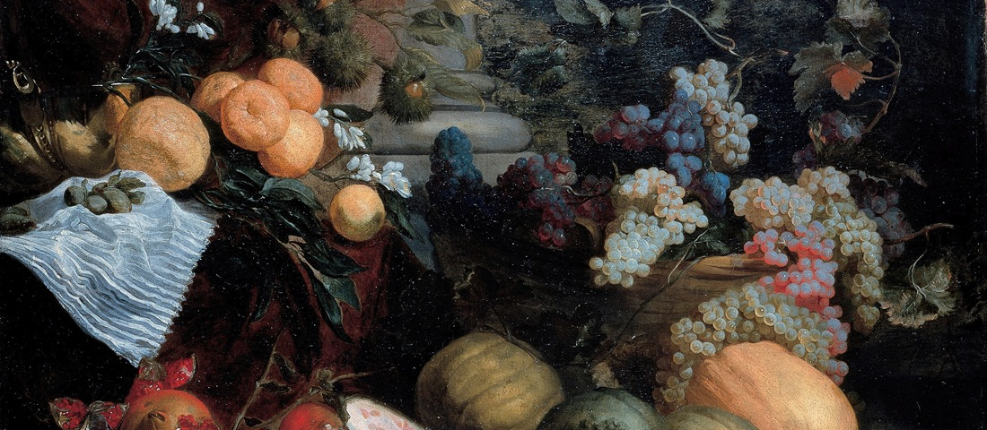 A painting of a still life with dark fabric of red and green draped and hanging in front of a column with several round edges at the base. There are leaves and dried pods placed throughout the fruits and vegetables, several clusters of dark purple, light green, light red grapes and vines filled and overflowing a light brown woven basket. There are melons, gourds, fruit, and white flowers in front of the basket and to the side, with one gourd cut in half.