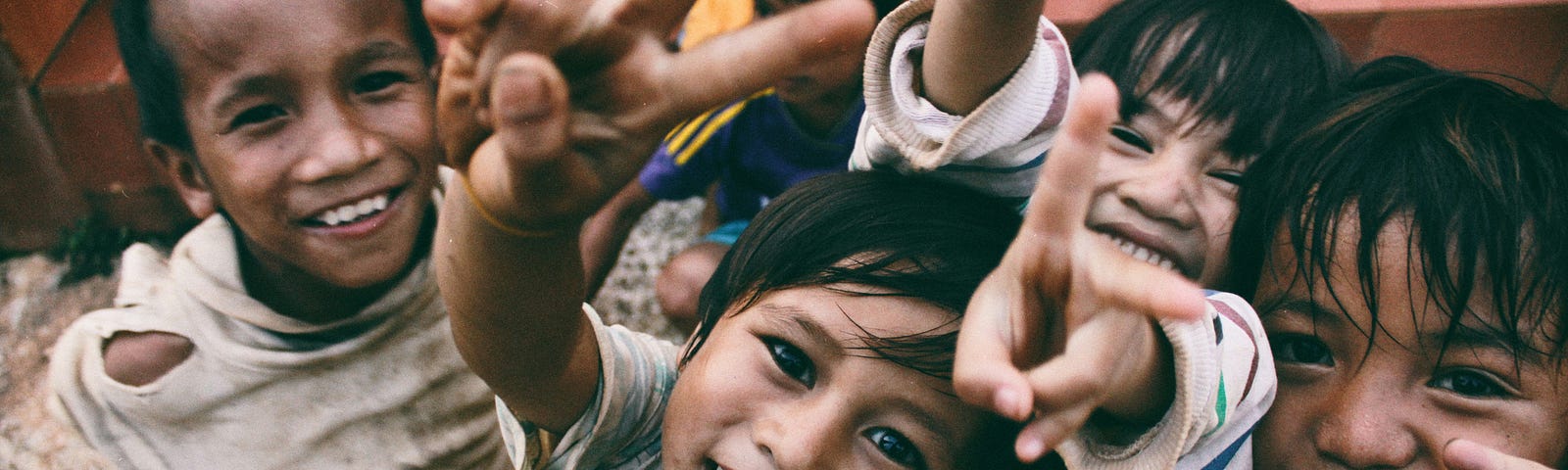 5 Happy kids, smiling and giving peace.