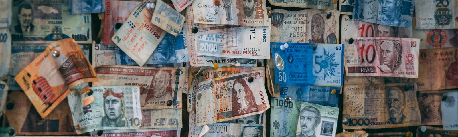 Various currency notes pinned on a wall