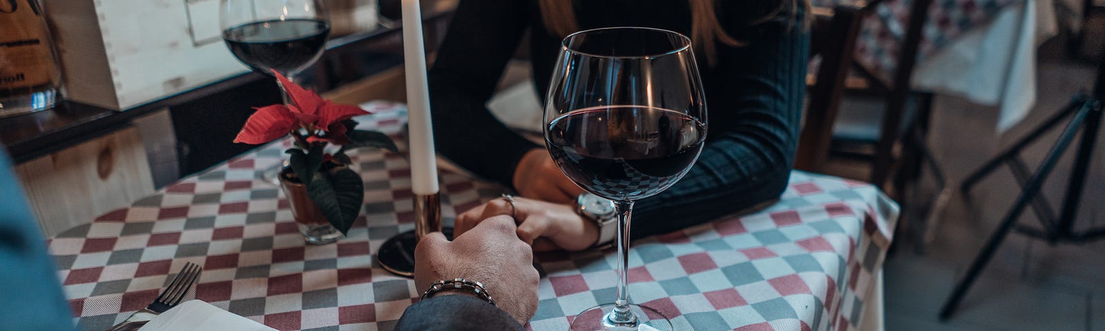 Woman and man having red wine on a date at an Italian restaurant