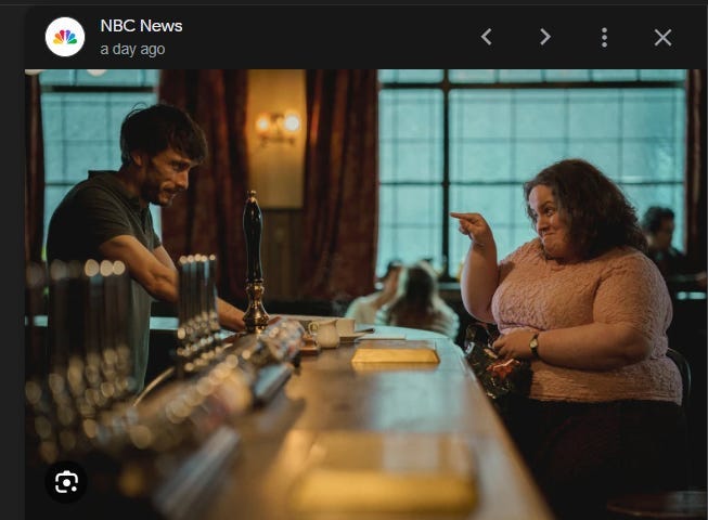 Screenshot of NBC’s news coverage of Baby Reindeer, a show on Netflix. Image is of a bar with a male bartender behind it and a female patron seated at a stool. The two are engaged in what appears to be witty banter. These are the two main characters in the show.