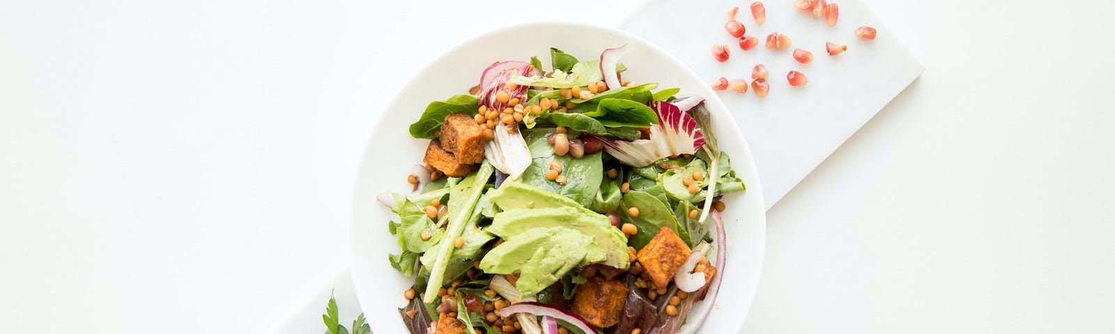 A salad on a white plate, atop a diagonal white folded napkin. Today, I’ll explore how the United Kingdom Biobank offers a tasty twist on diet to extend your lifespan.