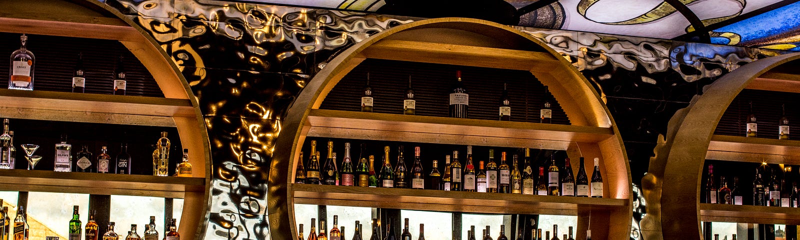 large wooden circles displaying wine bottles against a mirror