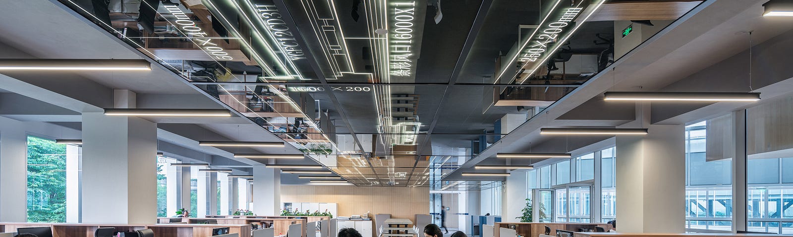 Image of workers working in an open plan office for article by Larry G. Maguire