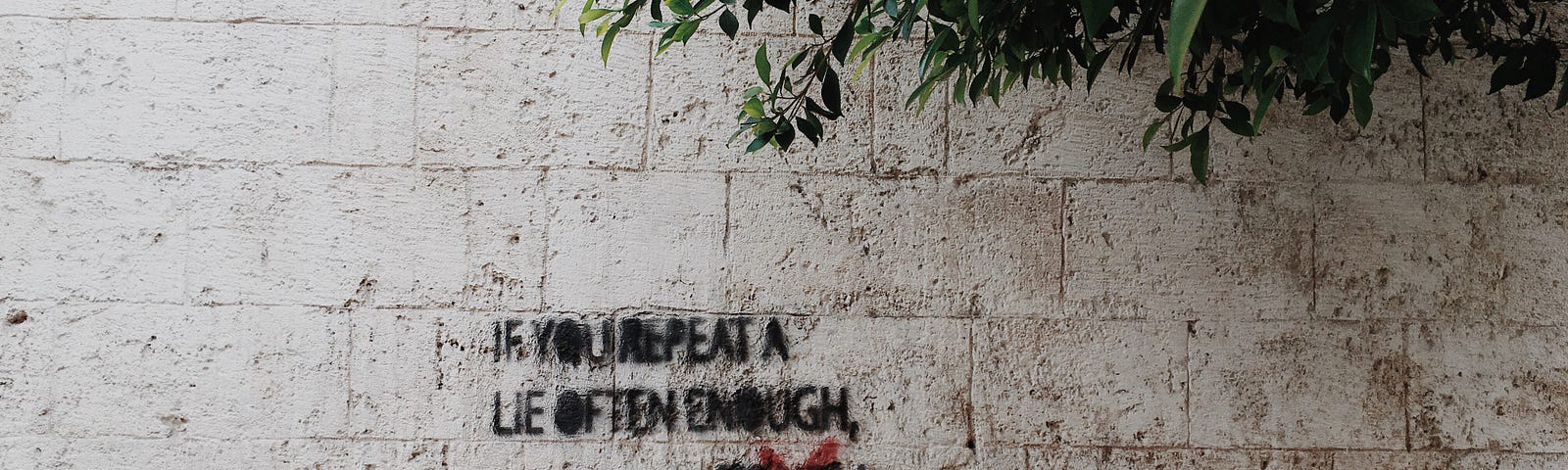A piece of graffiti on a stone wall. “If you repeat a lie often enough it becomes truth!” But the word ‘truth’ is crossed out, replaced by ‘POLITICS’ in large red letters.