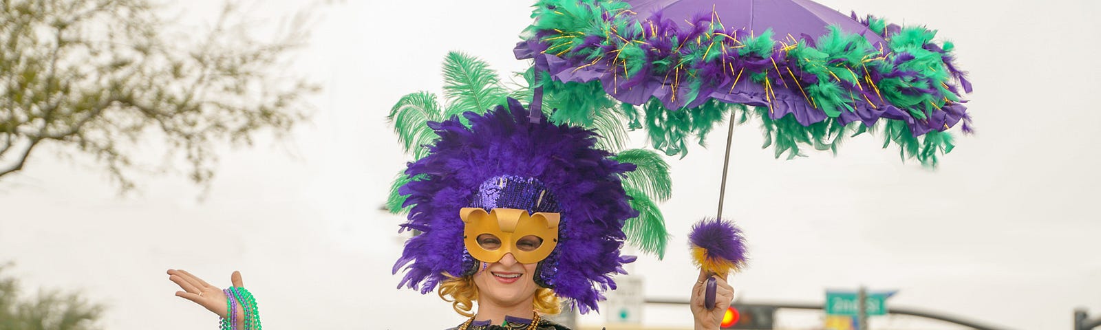 Carnival character in purple and green with mask and matching parasol