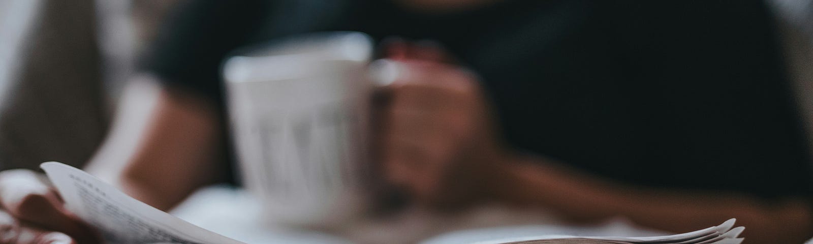 Woman relaxing with a book and a beverage/