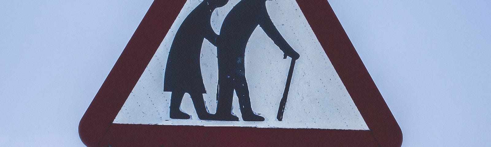 Picture of an elderly couple on a road sign via Alt text on Medium