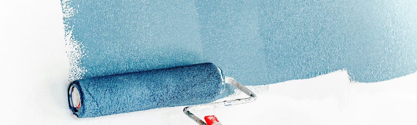 An image of a white wall being painted with light blue colored paint.