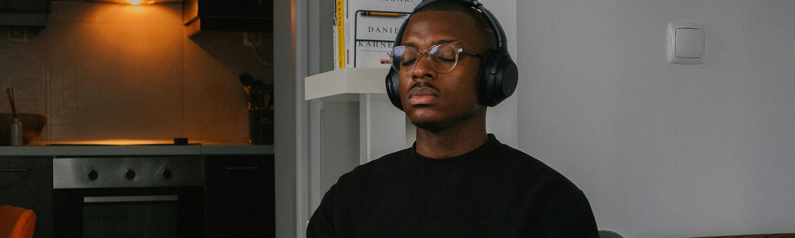 Man sitting with his eyes closed and wearing headphones.